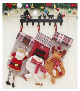 Three Christmas stockings featuring Santa, Snowman, and Reindeer hanging on a warm wall