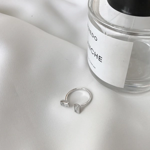 Detailed shot of open sterling silver ring with two rectangular stones on silk