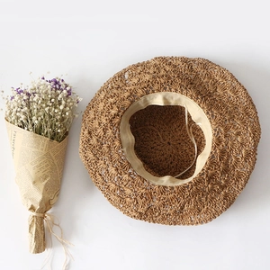Handwoven straw sun hat with wavy scalloped edge and floral lace details for beach