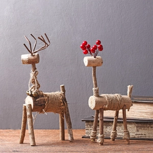 Detailansicht handgefertigter Rentierfiguren aus Holz mit Jute und roten Beeren-Dekor