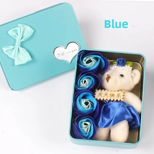 Detail view of heart-shaped gift box with blue soap roses and a plush bear