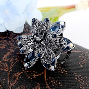 Macro shot of blue crystal flower hair claw with silver hollow metal and sparkling rhinestones