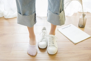 Close-up of invisible light purple cotton socks worn with white sneakers and blue jeans