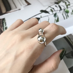 Detail of S925 sterling silver open ring with double asymmetric beads on a model's hand