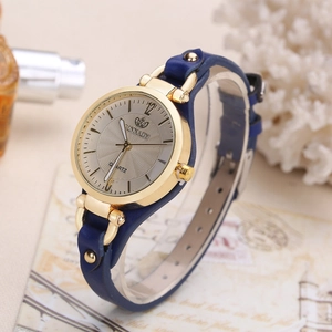 Close-up of elegant women's quartz watch with gold case, silver dial and blue leather strap