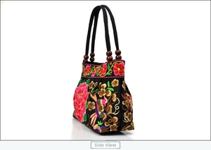 Detailed side view of ethnic canvas handbag with floral embroidery and wooden beads