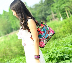 Ethnic canvas tote bag featuring intricate floral embroidery and decorative wooden beads