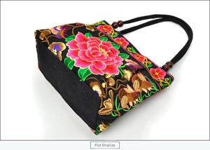 Detailed embroidery of peony flowers and a rabbit on a black ethnic canvas handbag