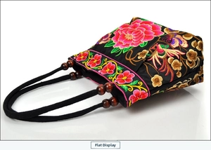 Detail of colorful peony embroidery and wooden beads on ethnic canvas handbag