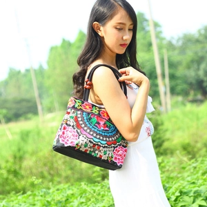 Ethnic style black canvas tote bag with floral embroidery and reddish brown wood beads