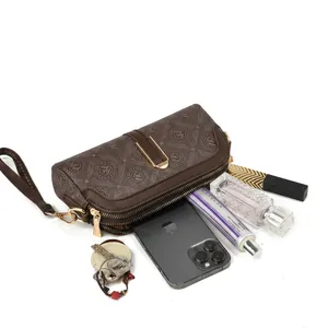 Detail view of brown monogram crossbody bag with dual zipper compartments and large storage