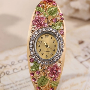 Detail showing pink enamel flowers and crystals on the golden hollow floral bracelet watch