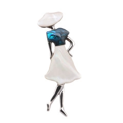 Macro shot of woman figure brooch with blue abalone and white shell inlay detail