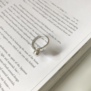 Minimalist S925 sterling silver open ring with double polished spheres on a book page