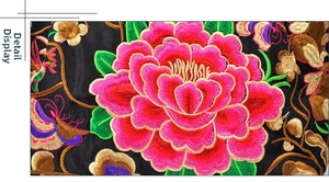 Detailed macro view of high-density pink peony embroidery on black canvas fabric