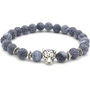 Macro view of silver leopard head charm on 8mm blue cracked pattern stone beads bracelet