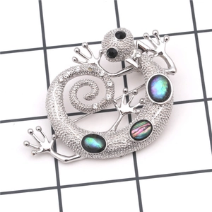 Detailed view of silver lizard brooch featuring colorful faux opal inlays and crystals