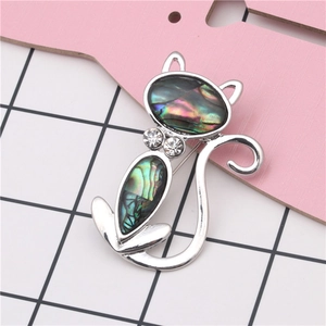 Detailed view of cat brooch with iridescent abalone shell inlay and rhinestone collar