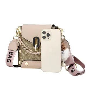 Detail of monogram messenger bag with pink leather trim and wide graphic strap