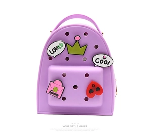 Detail of purple silicone mini backpack featuring cute Jibbitz charms and hollow design