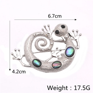 Detailed view of handmade lizard brooch with abalone shell inlays and crystal stones