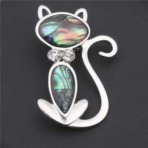 Macro shot of handcrafted cat brooch with iridescent abalone shell and rhinestones