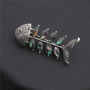 Detail of fishbone brooch with iridescent abalone shell inlays and vintage silver texture