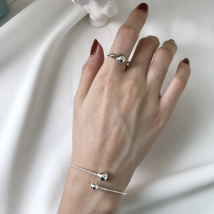 Dettaglio del bracciale a corda in argento S925 e anello con doppia sfera abbinato su raso