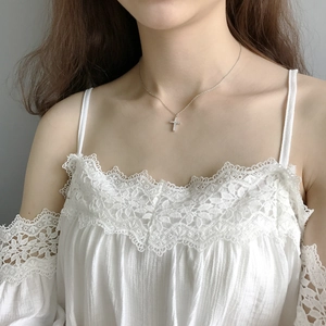 Close-up of S925 silver cross necklace with pavé micro-diamonds worn on a model