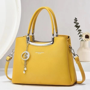Macro view of yellow litchi leather bag texture with star pearl charm and metal handle