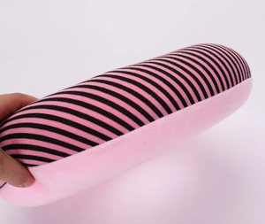 Close-up of pink and black striped plush travel pillow with soft foam particle filling