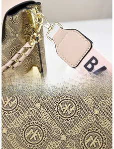 Detailed close-up of golden metal hardware and textured monogram leather on women's bag