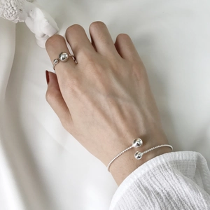 Dettaglio del bracciale a corda in argento S925 e del set di anelli a doppia sfera lucida