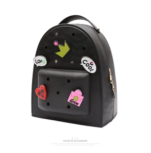 Detail of black silicone bucket backpack with DIY cartoon charms and golden zipper