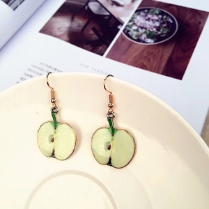 Detailed view of green apple cross-section earrings with glossy finish and gold metal edges