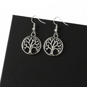 Close-up of vintage silver Tree of Life earrings with hollowed-out alloy pendants