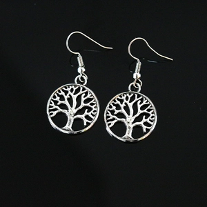 Close-up of silver Tree of Life drop earrings with hollow round design and fish hooks