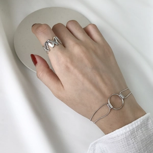 Macro shot of S925 sterling silver geometric hollow ring and round link chain bracelet