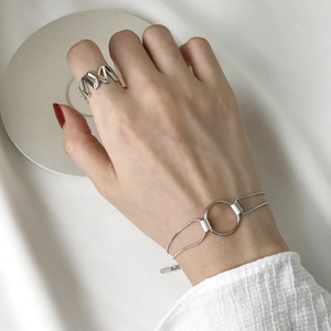 Close-up of S925 sterling silver geometric chain bracelet and jagged open ring on model