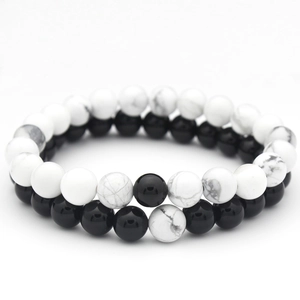 Detailed close-up of black matte beads and white turquoise couple bracelets set