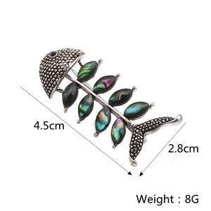 Detailed view of abalone shell fishbone brooch with 4.5cm by 2.8cm dimensions