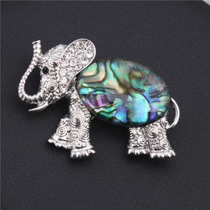 Macro detail of elephant brooch featuring colorful abalone shell and crystal pavé stones