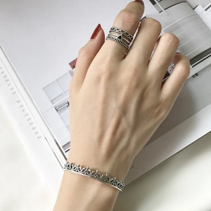 Silver crown lace open bangle and geometric stackable rings on a model hand