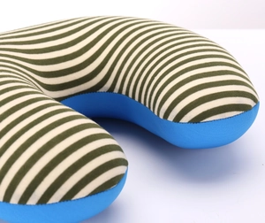 Detailed close-up of U-shaped travel pillow featuring green white stripes and blue fabric