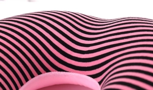 Close-up of pink and black striped U-shaped neck pillow with soft skin-friendly fabric