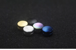 Close-up of five magnetic stud earrings in gold, silver, black, blue and rainbow colors