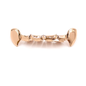Macro shot of rose gold vampire fang grillz featuring high polish and sharp tooth design
