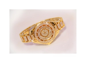 Detailed close-up of a luxury gold-tone women's watch featuring full diamond encrusting
