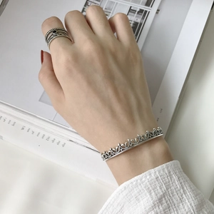 Detail of vintage 925 silver cuff bracelet with crown hollow design and stacking rings