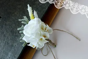 Detail of white calla lily and rose boutonniere with rustic jute twine wrapped stem